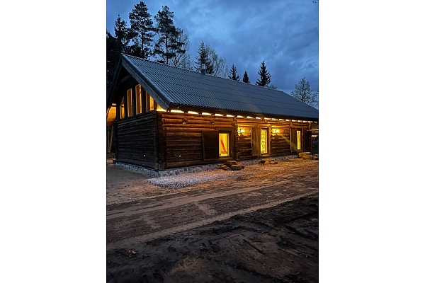 Guļbūves māja vakarā ar apgaismojumu
