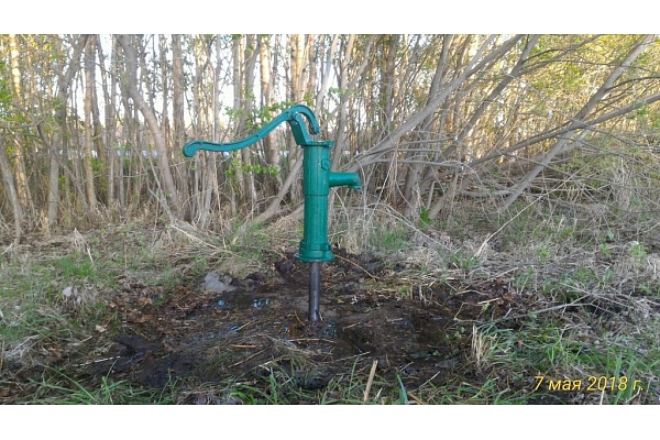 Rokas ūdens pumpis uz spices akas dārza