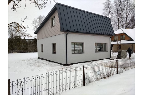 Privātmāja ar metāla jumtu ziemas apstākļos