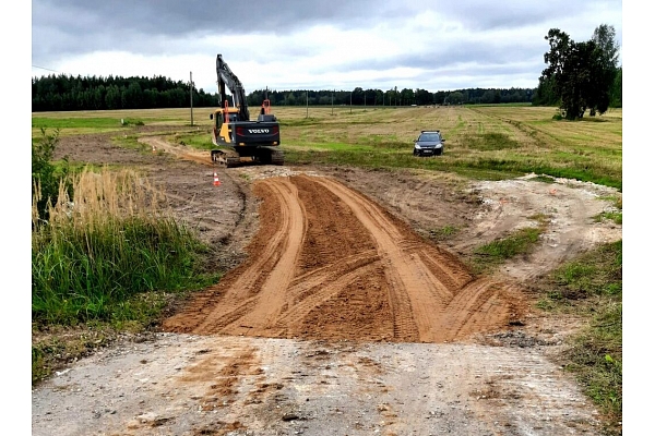 "Valmieras ceļi" ekskavators strādā pie grants ceļa būvniecības lauka Vidzemē
